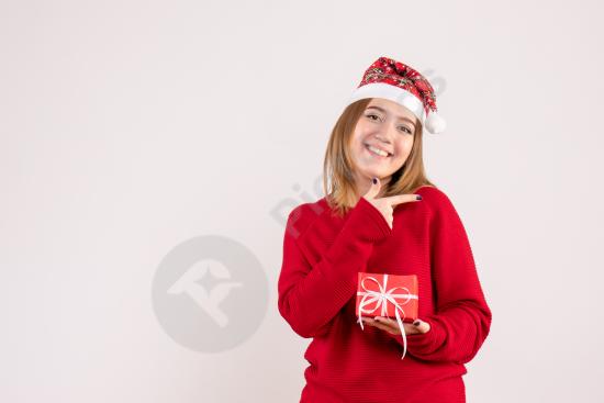 Front view of a young woman holding a small Christmas gift, perfect for holiday themes, festive promotions, and seasonal designs.