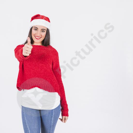 Young woman in a Santa hat giving a thumbs up, showing a cheerful and festive holiday mood—perfect for Christmas themes and seasonal promotions.