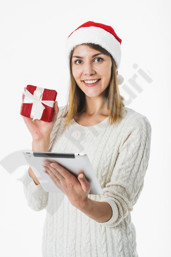 Woman holding a tablet and a gift box, perfect for themes about online shopping, holiday sales, digital gifts, and festive promotions.