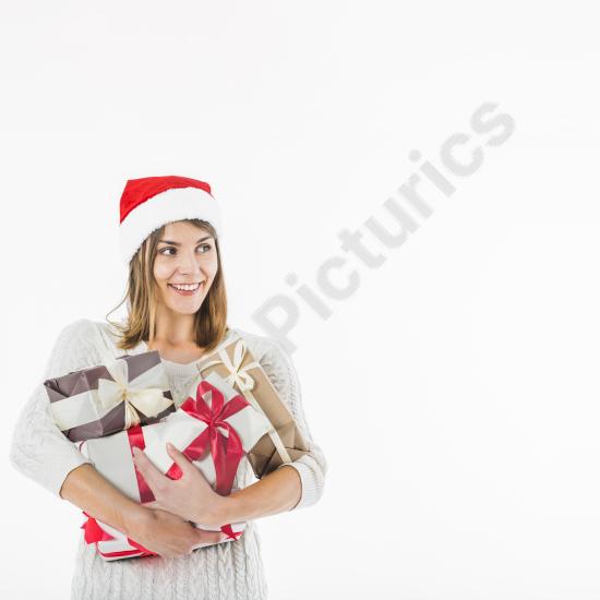Smiling woman wearing a Santa hat holding stacked gift boxes, perfect for Christmas, holiday promotions, and festive seasonal designs.