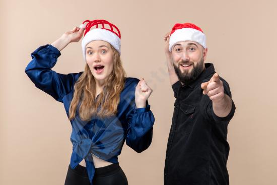 Front view of a young woman and man expressing mixed emotions against a pink background, perfect for lifestyle, relationship, and emotion-based concep...