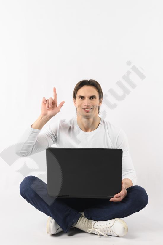 Man holding a laptop and pointing, representing presentation, explanation, business communication, and modern digital work.
