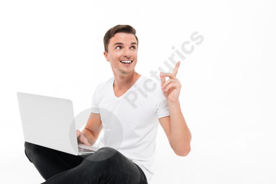 Portrait of a cheerful handsome man holding a laptop computer, representing confidence, modern work, and digital lifestyle.