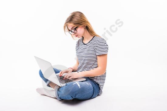 Beautiful woman sitting on the floor using a laptop, representing freelance work, remote job, home office, and modern casual lifestyle.
