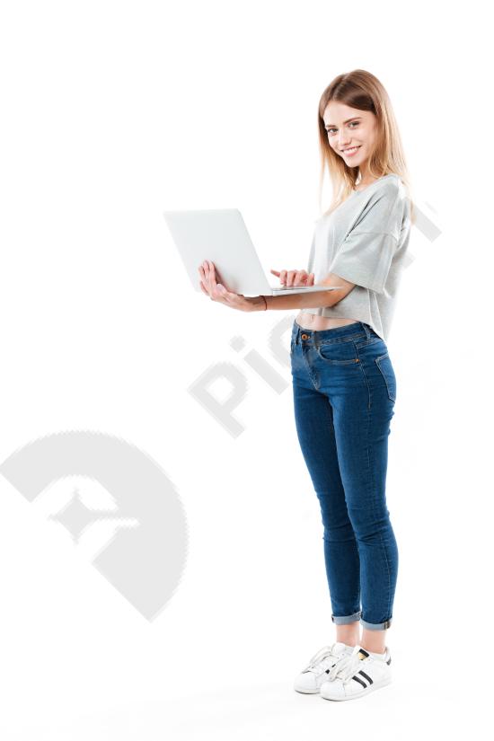 Full length shot of a woman using a laptop computer, representing remote work, business, productivity, and modern digital lifestyle.