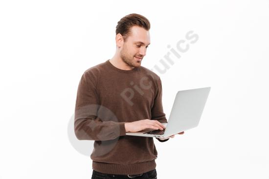 Handsome young man using a laptop computer, representing remote work, productivity, business, and modern digital lifestyle.
