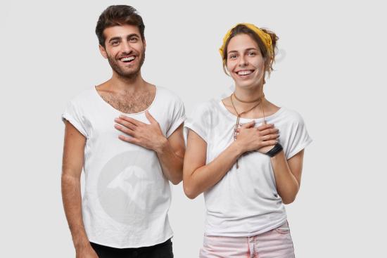 Pleased woman and man smiling with hands on chest, expressing gratitude, appreciation, happiness, and positive emotional connection.