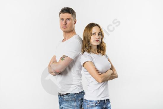 Sad young couple standing back to back on a white background, expressing conflict, emotional distance, and relationship problems.