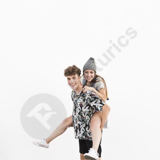 Happy man giving his girlfriend a piggyback ride on a white background, expressing love, fun, playfulness, and joyful relationship moments.