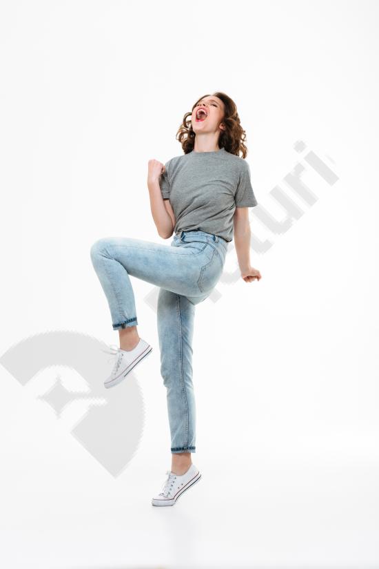 Excited young Caucasian woman making a winner gesture, expressing success and happiness, perfect for motivation, marketing, and ads.