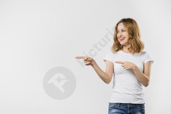 Smiling young woman pointing with her fingers, isolated on white background, ideal for advertising, promotions, and marketing concepts.