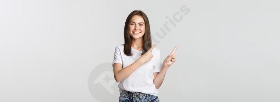 Satisfied smiling brunette girl pointing fingers to the upper left corner, showing a logo or copy space, isolated on white background.