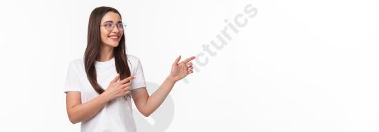 Waist up portrait of an amused and pleased brunette girl wearing glasses, smiling and pointing with her fingers, ideal for ads and promotions.