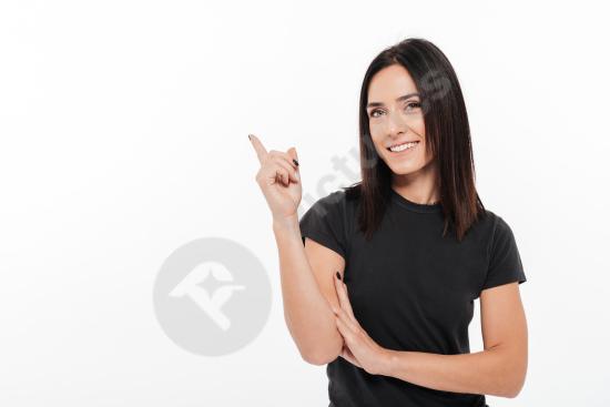 Portrait of a happy young woman pointing her finger away, expressing positivity and direction, ideal for advertising and marketing concepts.