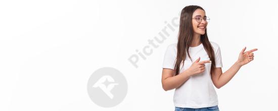 Waist up portrait of a cheerful young female student programmer pointing to the right, smiling with confidence, ideal for tech, education, and marketi...