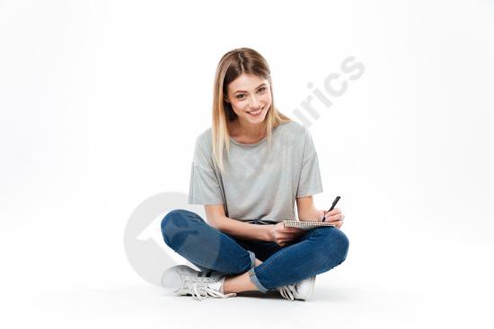 Young woman using a pencil to write in a notebook, focused on studying, planning, or creative work in an educational or lifestyle setting.