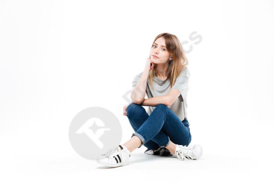 Thoughtful woman sitting cross legged, expressing calm reflection or contemplation, ideal for lifestyle, mental health, or creative concepts.
