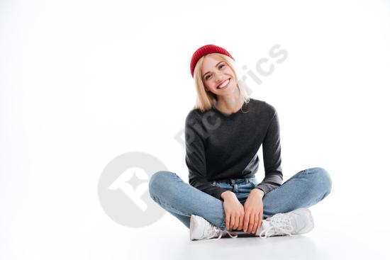 Smiling female hipster sitting on the floor in a relaxed pose, perfect for lifestyle, casual fashion, creative, or modern portrait concepts.