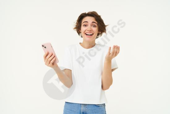 Happy brunette woman smiling and laughing while using a mobile phone, representing technology, communication, and modern lifestyle.