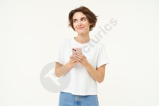Portrait of a brunette woman standing and using a smartphone, texting or placing an online order through a mobile app in a modern lifestyle setting.