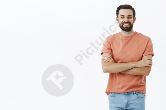 Expressive bearded man wearing an orange t-shirt, showing emotion and personality in a casual portrait suitable for lifestyle or creative concepts.