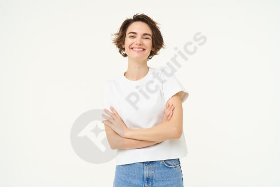 Portrait of a cheerful woman laughing and smiling with arms crossed, standing confidently in a power pose, ideal for business or lifestyle concepts.