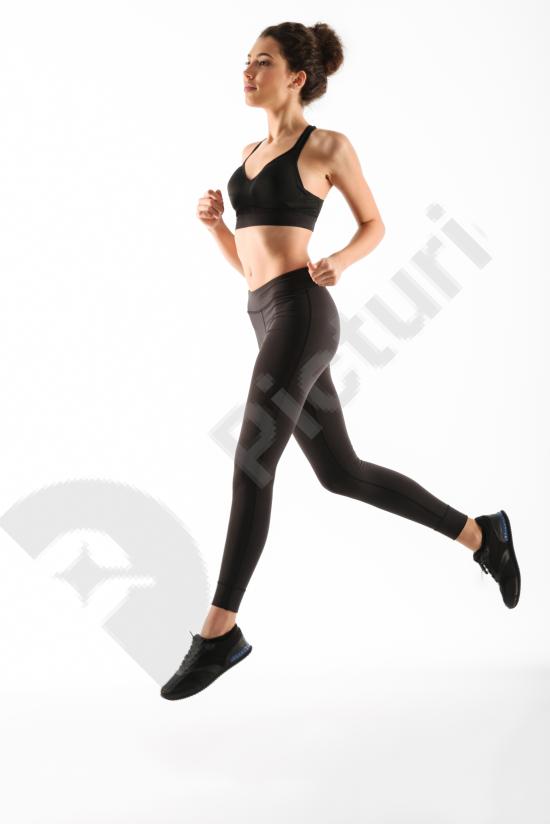 Smiling fitness woman running during workout, representing healthy lifestyle, cardio training, energy, and active sports motivation.