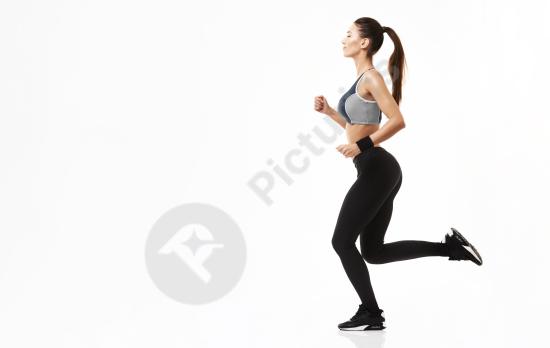 Sportive woman in sportswear running during training, isolated on white background, concept of fitness, healthy lifestyle, and active movement.