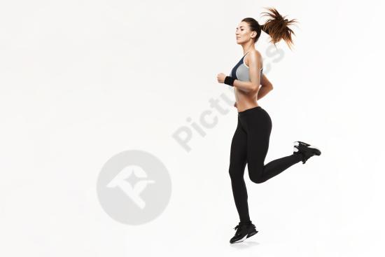 Athletic woman in sportswear running during training, isolated on white background, symbolizing fitness, healthy lifestyle, and dynamic movement.