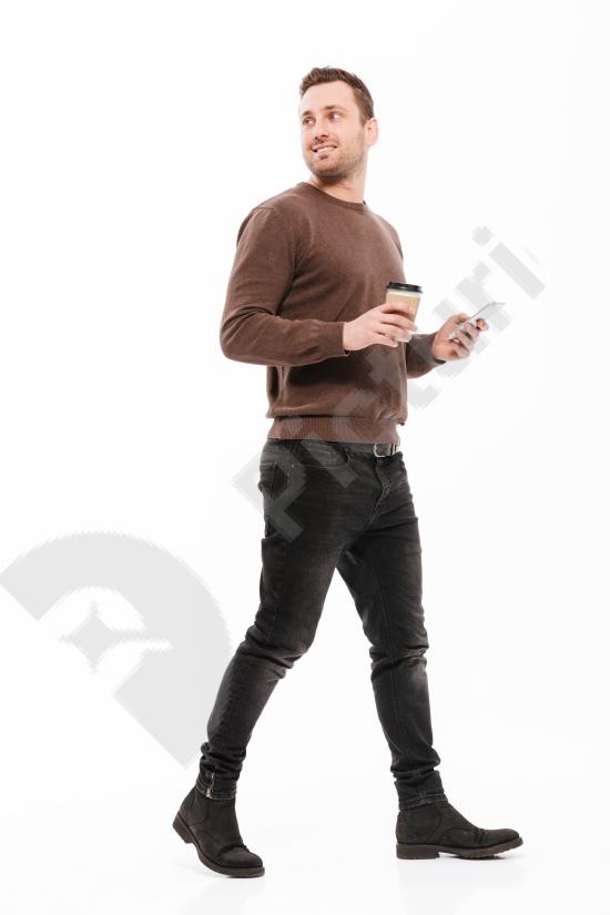 Full-length portrait of a happy young man walking and smiling, isolated on a clean background. Casual lifestyle concept with positive energy.