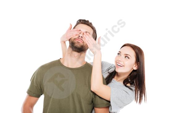 Happy young loving couple standing together isolated on background. Warm romantic portrait perfect for relationship, love, and lifestyle concepts.